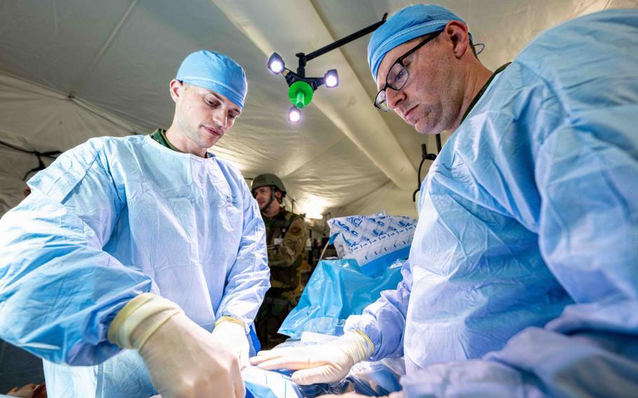 U.S. Navy Lt. Michael Fisher, general surgeon, right, and Lt. Commander Mat Bowers, orthopedic surgeon, both assigned to the 3rd Medical Battalion, 3rd Marine Logistics Group, simulates treating abdominal injury during a U.S. Air Force led operational exercise Beverley Midnight 26 at Kadena Air Base.